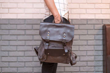 Man holding brown leather bag in the hand
