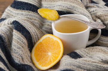 cozy autumn Breakfast with tea in white cup with honey and a warm knitted sweater