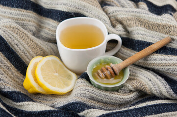 cozy autumn Breakfast with tea in white cup with honey and a warm knitted sweater