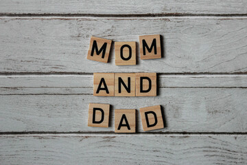 Word mom and dad on a wooden background