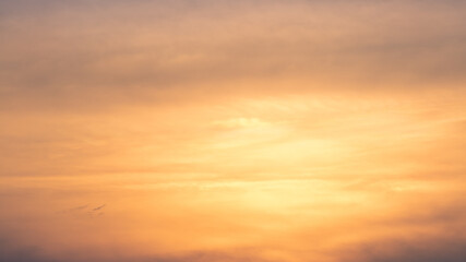 Wonderful view of cumulus clouds sky with orange sun light at sunset of summer