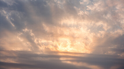 Wonderful view of cumulus clouds sky with orange sun light at sunset of summer
