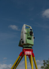Machine for surveyors with blue sky and green trees in sunny day