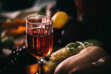 Glass of rose wine or cider in wine glass in a moody autumn vintage atmosphere