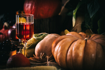 Glass of rose wine or cider in wine glass in a moody autumn vintage atmosphere