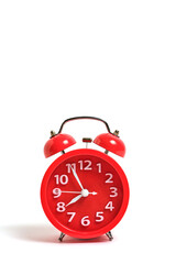 Red alarm clock isolated on white background shows 7 hours 55 minutes morning, wake up for school or work.