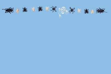 plastic skeletons, white and black, insects, fly, spider on a blue background. Halloween card. Copy space.