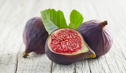 Figs with leaves on white wooden background