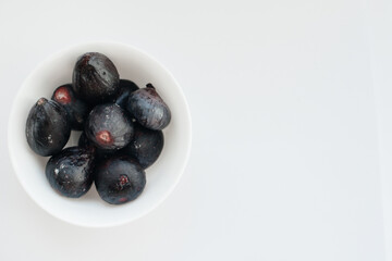 Ripe and sweet figs cut and arranged in a plate on a white background with free space. Fruits and vegetarianism