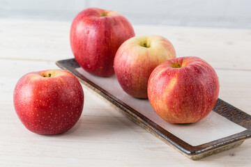 Juicy beautiful red Gala apples on white wooden table