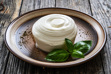 Fresh ricotta cheese and vegetables on wooden table
