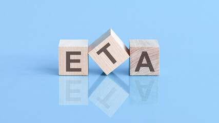 ETA word is made of wooden building blocks lying on the blue table, concept