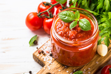 Tomato sauce. Traditional italian tomato sauce with fresh tomatoes, herbs and spices at white kitchen table.