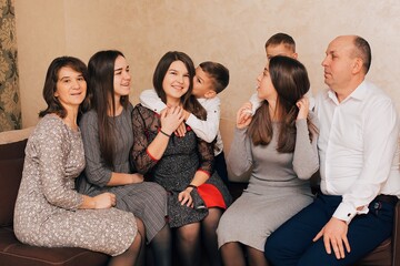 Christian large family. Big family at home on the couch. Family evenings. Parents' love for children

