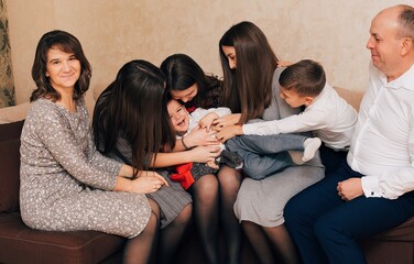 Fototapeta premium Christian large family. Big family at home on the couch. Family evenings. Parents' love for children 