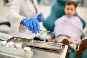 Close-up of dentist using sickle probe during dental examination of a child.