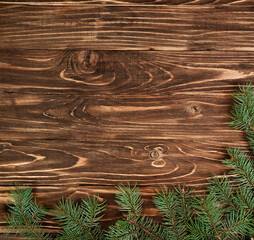 Fir branches on a brown wooden background. Christmas background.