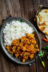 Cauliflower tikka masala or gobi curry served with rice and roti, selective focus