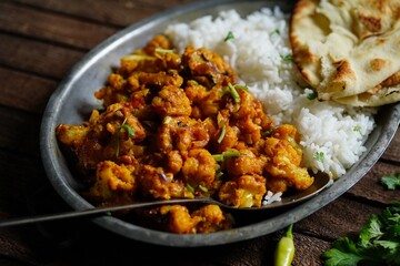 Cauliflower tikka masala or gobi curry served with rice and roti, selective focus