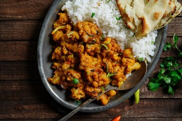 Cauliflower tikka masala or gobi curry served with rice and roti, selective focus