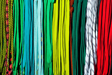 Multicolored ropes in the store on the counter. Display of bright colorful shoe laces in a shop.