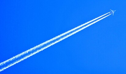 Blauer Himmel und Flugzeug mit Kondensstreifen