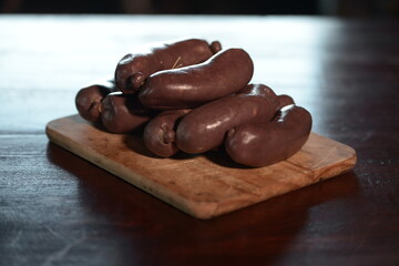 Black pudding on a cutting wood on a brown wooden table.