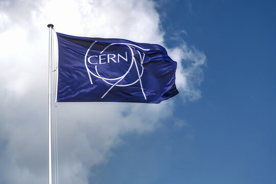 MEYRIN, CANTON OF GENEVA, SWITZERLAND - AUGUST 31, 2021: Flag of CERN. Logo, symbol of the European Organization for Nuclear Research, operating the largest particle physics laboratory in the world. 