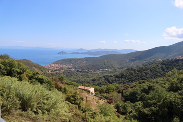Elba, Italy – September 01, 2021: beautiful places from Elba Island. Aerial  view to the island. Little famous villages near the beaches. Summer tourist places. Clouds and blue sky in the background.