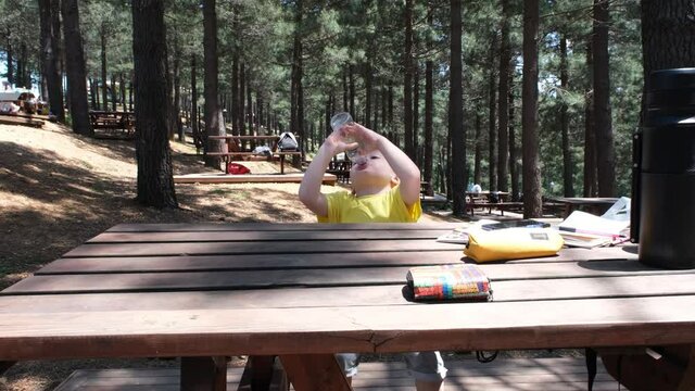 drinking water, caucasian boy drinking water with bottle on bench