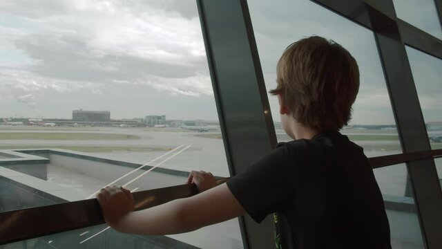 Young traveller likes watching departing planes at the airport