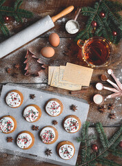 Freshly baked Christmas cookies with recipe cards and baking ingredients