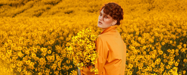 Portrait of red haired women dressed in trendy fall orange trench coat in colourful orange field. Fashion clothes autumn look