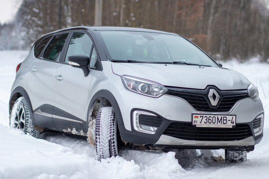 Grodno, Belarus-01.31.2021: Renault Capture or Renault Kaptur SUV on a winter road against the background of a field and forest. Winter driving conditions in Renault on a snowy road
