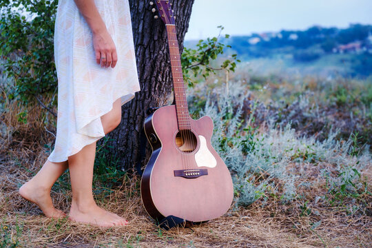 Beautiful romantic background with guitar outdoor. Photo of sensual woman. Art work. Music background