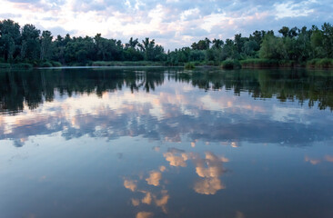 Beautiful landscape with reflection of trees and clouds in the lake