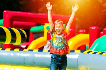 Child jumping on colorful playground trampoline. Kids jump in inflatable bounce castle on birthday...