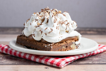 brownie postre de chocolate con crema visto de frente en primer plano
