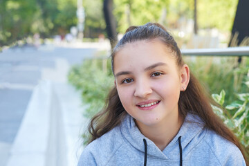 Child teenager girl with  backpack sits and smiles. Online learning, distance education, home schooling.