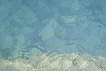 Water surface with ripples in daylight with different shades of colors