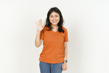 Waving hand Greeting Gesture of beautiful asian woman Wearing orange T-shirt isolated on white background