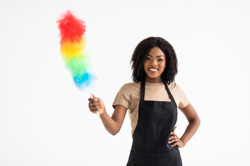 Happy young african housewife holding duster - isolated on white background