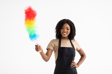 Happy young african housewife holding duster - isolated on white background