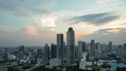 Fototapeta na wymiar Aerial view of Asia Business concept for real estate - panoramic modern cityscape building bird eye aerial view under sunset and blue bright sky in Jakarta. Jakarta, Indonesia, September 23, 2021