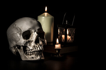 czaszka i świece na ciemnym tle - obrazy, fototapety, plakaty