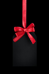 black tag with red bow on black isolated background