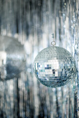 A mirror ball in a room decorated with silver decor. 