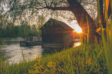 Beautiful old wooden mill on mura river or mlin na muri in the pomurje region of slovenia on a romantic summer sunset - obrazy, fototapety, plakaty