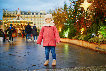 Adorable preschooler girl on Christmas market in Paris, France