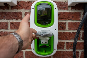 Electric vehicle domestic charging point installed outside of the house on new housing development...